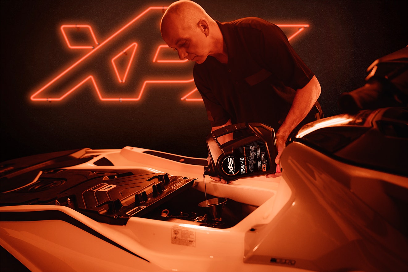 Man adding XPS 5W-40 oil to his Personal Watercraft